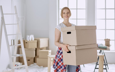 A beautiful single young woman unpacking boxes and moving into a new home