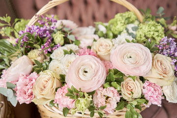 Flowers delivery. Flower arrangement in large Wicker basket. Beautiful bouquet of mixed flowers in woman hand. Floral shop concept . Handsome fresh bouquet.