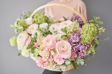 Flowers delivery. Flower arrangement in large Wicker basket. Beautiful bouquet of mixed flowers in...