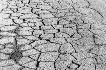 Texture of gray cracked asphalt. Abstract backdrop for design.