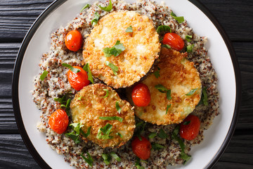 Delicious baked eggplant served with multi-colored quinoa close-up on a plate. Horizontal top view