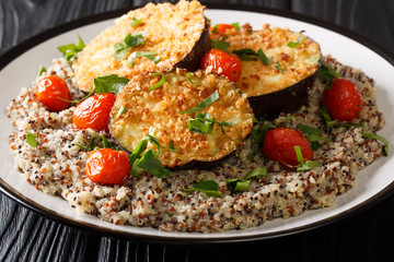 Vegetarian food baked eggplant in breadcrumbs with a side dish of quinoa closeup on a plate. horizontal