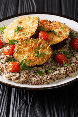 baked eggplant with tomatoes with a side dish of quinoa closeup on a plate. vertical
