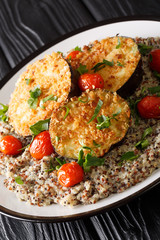 Fitness menu baked eggplant with tomatoes and quinoa closeup on a plate. vertical