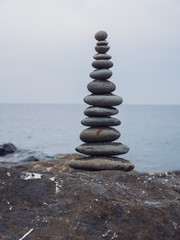 Zen stones on the beach piled by a tower