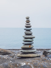 Zen stones on the beach piled by a tower