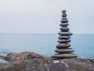 Zen stones on the beach piled by a tower