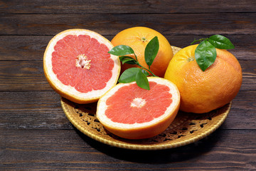 Grapefruit fruits on a wooden table. Healthy food. Brown background. Grapefruits on a tray.