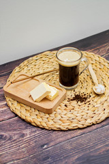 Keto bulletproof coffee in glass with metal straw with ingredients