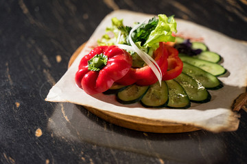 a plate of chopped vegetables, on a wooden table, vegetables, cucumber, sliced, pepper, onion, salad, tomato, parsley, a plate of vegetables
