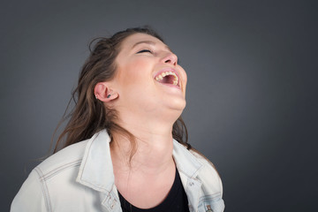 Joyful European woman having fun and laughs at good joke or sings wears casual clothes, standing...