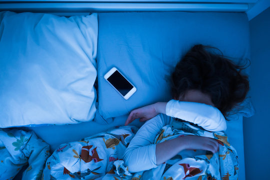 Small 11 Year Old Girl Sleeping In Bed On A Stomach.