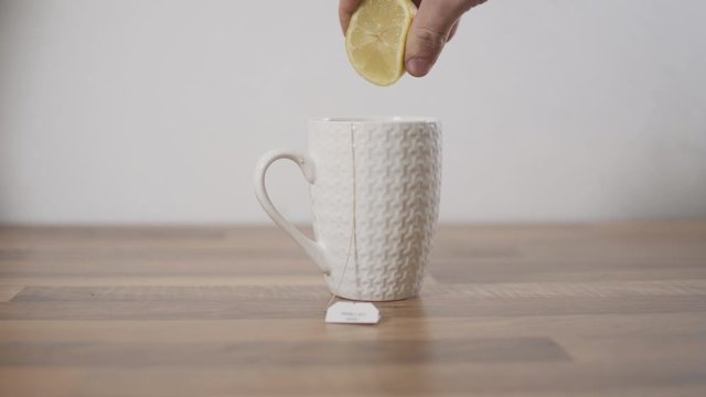 Zitrone ausquetschen in Tee