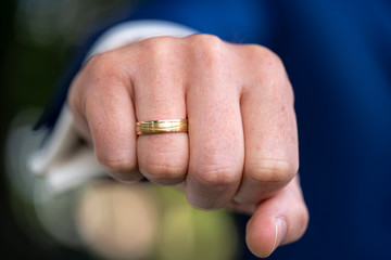 Close up of happy gold ring on men's finger