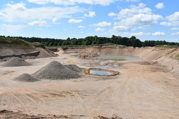 Gravel mine with water ponds and blue sky
