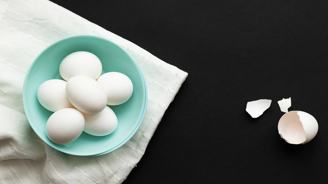 Traditional easter food eggs. Colored dishes on a White napkin and black background. Minimalistic design. Copy space. Colors Trend 2020