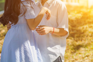 Valentine couples are talking and standing holding hands on a blurred background in the morning to...