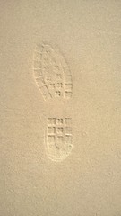 Single boot imprint in beach sand