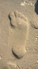 Single bare foot imprint in beach sand