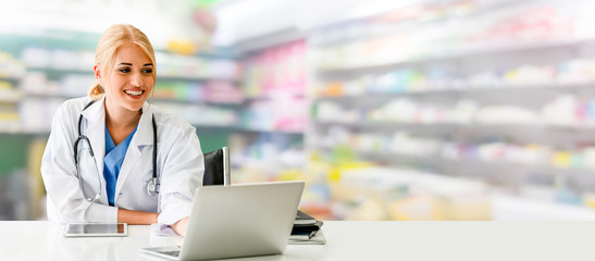 Pharmacist or doctor using laptop computer at the pharmacy room. Medical healthcare and pharmaceutical staff service.