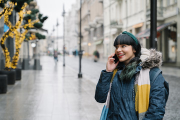 Obraz premium Stylish woman using smartphone in the street