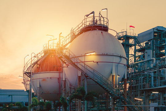 Gas storage sphere tanks in oil and gas refinery industrial plant with sunset sky background