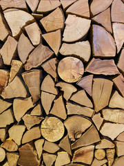 Close up of firewood stacks. Preparation of firewood for winter or wall decorated with wooden piles. Vertical mobile photo