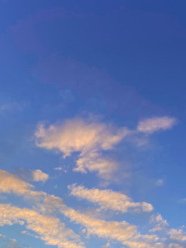 Sunrise in blue sky with pink clouds. Abstract vertical mobile photo