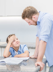 Obraz premium Father helps his son doing homework at home