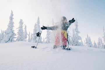 snowboarder female in snow-cowered trees  winter forest have fun and tossing snow