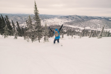 Fototapeta na wymiar Snowboarder male riding on snowboard in snow powder