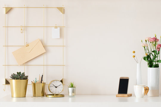 Modern office desk with gold accessories. Empty space, mock up. Minimal style.