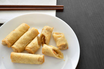 Spring rolls on a white plate with copy space on the right side. Selective focus.