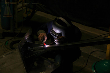 Obraz na płótnie Canvas Metal workers use manual labor. Skilled welder. Factory workers making OT. Welder is welding the steel in the factory. welder Industrial automotive part in factory.