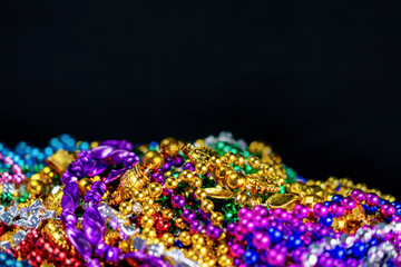Strings of colorful festival beads with a black background.  Selective focus.  Blurred foreground. ...