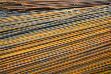Iron metal rusty yellow bars of industrial building reinforcement from corrugated reinforcement for the construction of buildings made of reinforced concrete. Texture, background