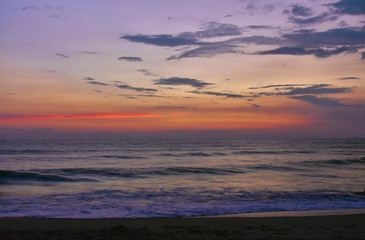 colorful reddish sky over the horizon with layer of sand in foreground