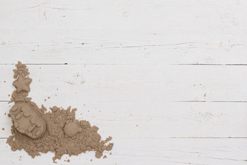 Top view of a space for playing with kenetic sand. The child built a sand castle and other objects using plastic molds. Early development for children.