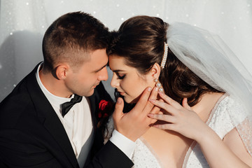 Amazing young gorgeous newly married couple taking a walk in the park on their wedding day. Nifty wedding couple enjoying each other's company