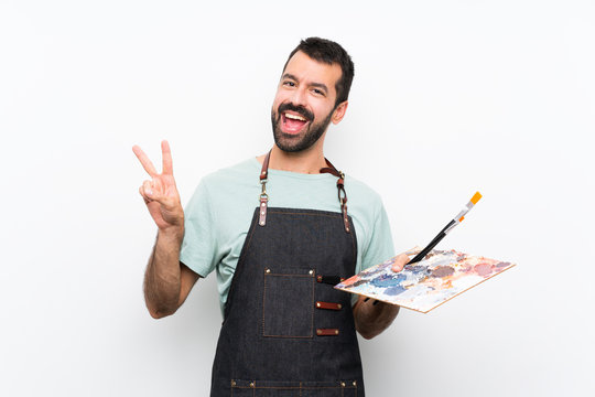 Young Artist Man Holding A Palette Over Isolated Background Showing Victory Sign With Both Hands