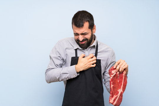 Chef holding a raw meat having a pain in the heart