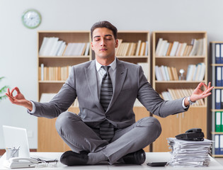 Handsome meditating on the office desk