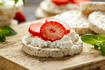 Rice crackers with ricotta and strawberries on wooden board. healthy food