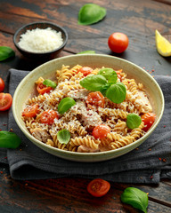 Healthy Chicken, fusilli pasta with tomatoes, basil and parmesan cheese. on wooden table.