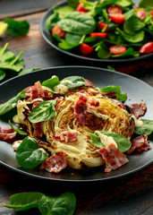 Oven roasted cabbage steaks with bacon, spinach and mayonnaise. healthy food