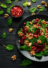Obraz na płótnie Canvas Healthy Beet Salad with fresh sweet baby spinach, pomegranate seeds and candy walnut. healthy Vegan vegetarian, plant based food