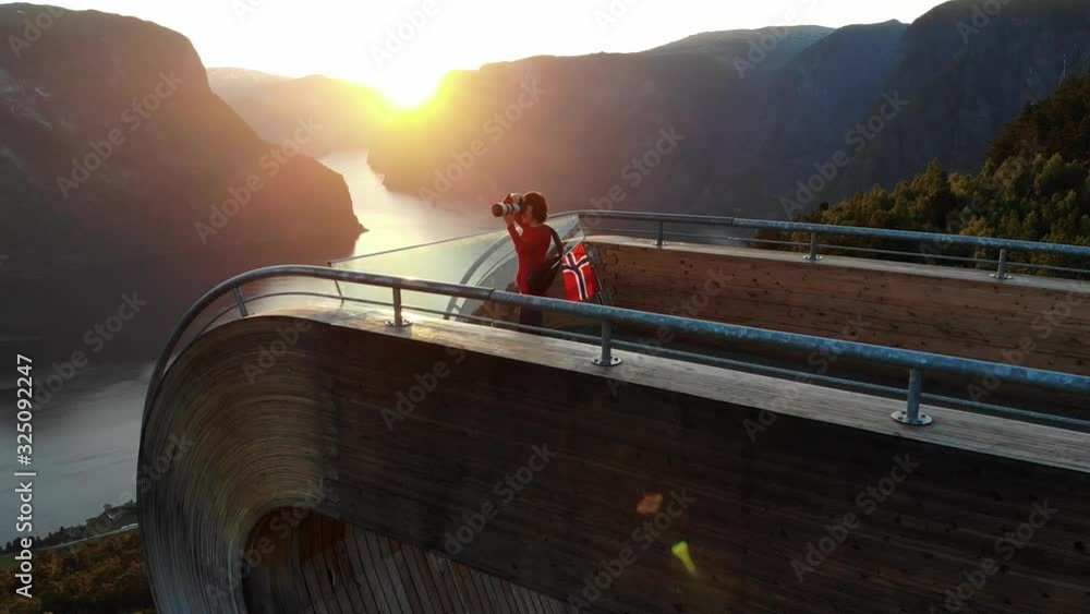 Poster aerial view. tourist woman with norwegian flag and photo camera enjoying fjord aurlandsfjord view fr