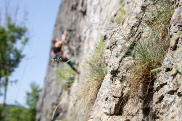 Klettererin in Unschärfe am Fels