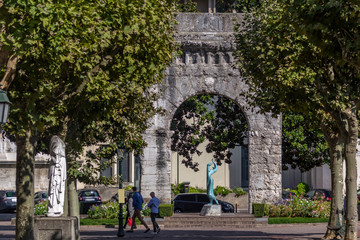 Fototapeta premium Ancient arch and modern blue sculpture in the historic center of Aix-les-Bains, France