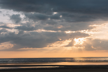 Dramatic scenic landscape above the sea. The sun rays break through the clouds. Gentle tones of the scenery. Travel and vacation concept. Saint Petersburg, Russia. Beauty world. Orange tones of sky.